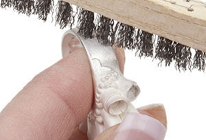 Ring being brushed with wire brush